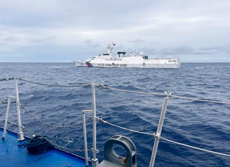 ２６日、南シナ海のサビナ礁の手前で、フィリピン沿岸警備隊の巡視船に接近する中国海警局の船（共同）