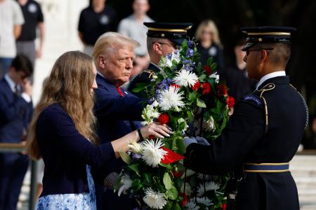 米アーリントン国立墓地で開かれた献花式に遺族と参列したトランプ前大統領（左から２人目）＝２６日、バージニア州（ゲッティ＝共同）