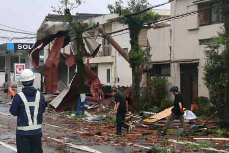 突風の被害を受けた宮崎市の大淀川河口付近の住宅街。電線には飛来物が引っかかり、道路には屋根瓦が散乱していた＝２９日午前