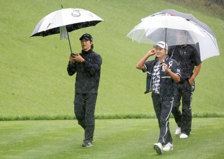 第２日、降雨順延となり、コースから引き揚げる石川遼（左）＝富士桜ＣＣ