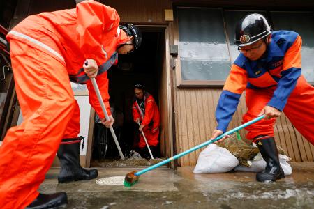 　大雨で浸水した岐阜県大垣市の住宅から水をかき出す消防団員ら＝３１日午後４時２５分