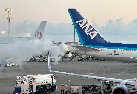 　補助エンジンから煙を上げる全日空機（右）＝１日午後、那覇空港（目撃者提供）