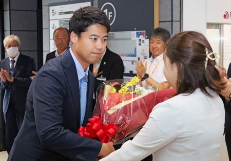 初当選した秋田県大館市長選から一夜明け、市役所で花束を受け取る石田健佑氏＝２日午前