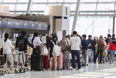 韓国・仁川国際空港で搭乗手続きのため列を作る乗客ら＝２０２２年（聯合＝共同）