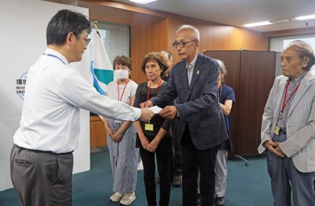 環境省で前田光哉環境保健部長（左端）に要望書を手渡す「水俣・写真家の眼」代表理事の芥川仁さん＝３日午後