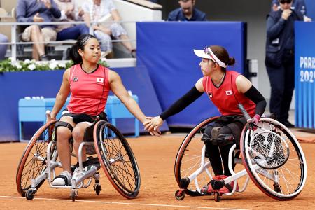 女子ダブルスで決勝進出を決め、タッチを交わす上地結衣（左）、田中愛美組＝パリ（共同）