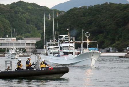 海保のゴムボート（手前）に見守られ、イルカなどの追い込み漁に向かう漁船＝５日早朝、和歌山県太地町