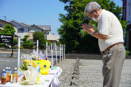 園の駐車場に設置された献花台で手を合わせる男性＝５日午前、静岡県牧之原市