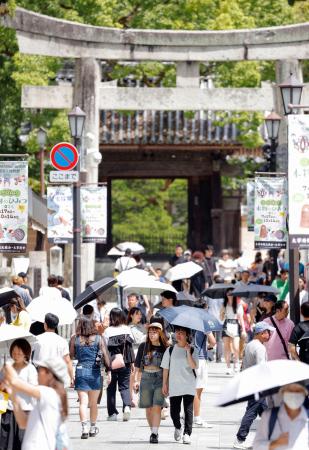 猛暑日となった福岡県太宰府市で日傘を差して歩く人たち＝８月