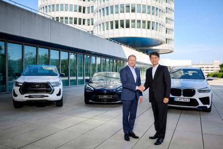 ＢＭＷのオリバー・ツィプセ会長（左）と握手するトヨタ自動車の佐藤恒治社長＝ドイツ・ミュンヘン（共同）