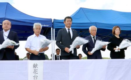 関東・東北豪雨で決壊した鬼怒川の堤防で、献花台に花を供える茨城県常総市の神達岳志市長（中央）ら＝１０日午後、常総市