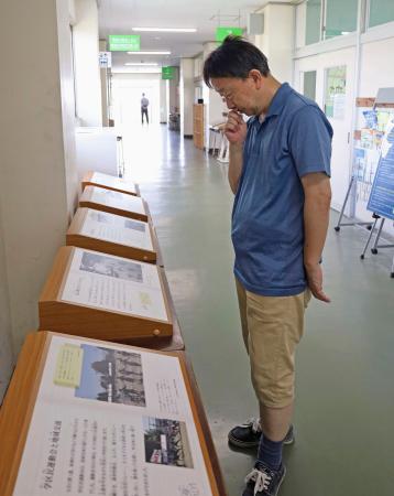 震災遺構・荒浜小を訪れ、東日本大震災前の地域の様子を記録した写真展示を見学する人＝１１日午前、仙台市