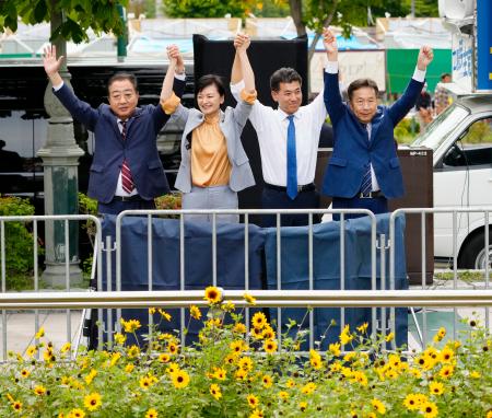 　立憲民主党代表選の演説会で手を取り合う（左から）野田元首相、吉田晴美衆院議員、泉代表、枝野前代表＝１６日午後、札幌市