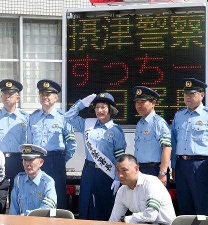 一日警察署長に任命され、署員らと記念写真に納まるすっちーさん（中央）＝１９日午後、大阪府警摂津署