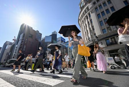 　強い日差しの中、東京・銀座で日傘を差して歩く人たち＝２０日午後