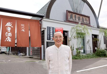 老舗しょうゆ蔵元の建物を改装した「咸亨酒店」と小川宣夫さん＝８月、茨城県常陸太田市