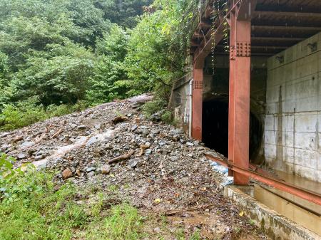 　大雨の影響で土砂崩れが起き、黒部峡谷鉄道のトンネル（右）内に土砂が流入した現場＝２２日午前１１時３５分、富山県黒部市（同社提供）