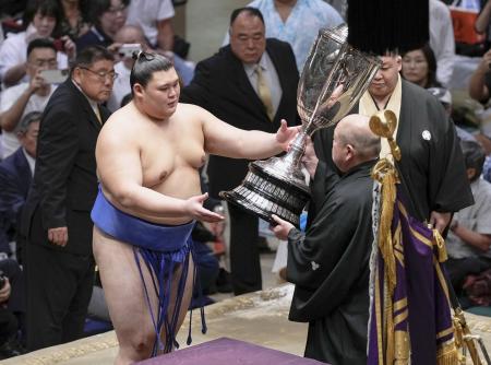 大相撲秋場所で２場所ぶり２度目の優勝を果たし、日本相撲協会の八角理事長（右）から賜杯を受け取る大の里＝２２日、東京・両国国技館