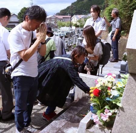 久保山愛吉さんが亡くなってから７０年、静岡県焼津市内にある墓に献花し、手を合わせる人ら＝２３日午前