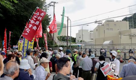 　関電社員に申し入れ書を手渡すため、高浜原発前に集まった人たち＝２３日午前、福井県高浜町