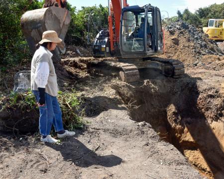 　長生炭鉱の坑内調査に向けて始まった掘削作業。左は「長生炭鉱の水非常を歴史に刻む会」の井上洋子共同代表＝２４日午前、山口県宇部市