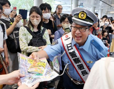 一日署長に任命され、反射材などが入った啓発品を配るチャンカワイさん＝２５日午後、名古屋駅