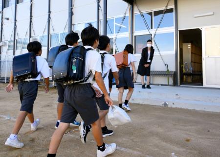 豪雨で休校していた小学校が再開し、登校する児童＝２６日午前、石川県輪島市