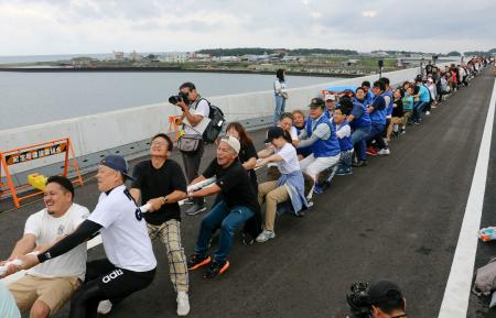 和歌山県新宮市と三重県紀宝町を結ぶ「熊野川河口大橋」で行われた綱引き＝２９日午前