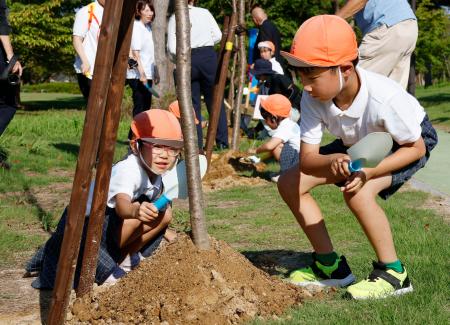 能登半島地震で被災した石川県七尾市の公園で、桜を植樹する地元小学生ら＝１日午後