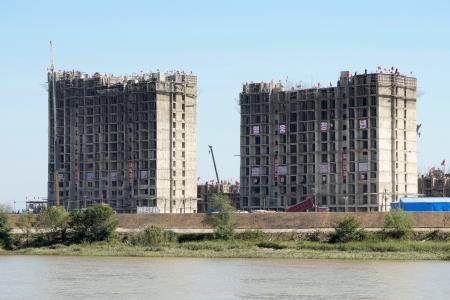 ７月に洪水被害を受けた北朝鮮・新義州で建設が進められる高層住宅＝４日、中国・丹東から撮影（共同）