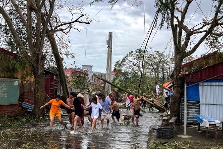 台風１１号による倒木をロープを使って撤去する人たち＝９月、ベトナム・ハイフォン（ロイター＝共同）