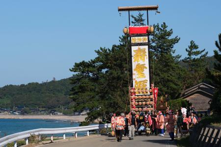 石川県珠洲市馬緤町で「馬緤キリコ祭り」が開かれ、地震と豪雨被害の爪痕が残る地区内を巡行する巨大な灯籠「キリコ」＝１３日午後