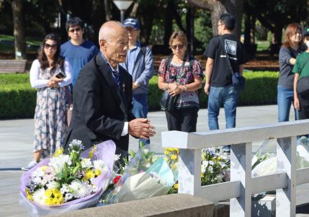 　原爆慰霊碑に献花し、手を合わせる広島県被団協の箕牧智之理事長＝１３日午前、広島市の平和記念公園