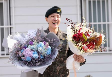 １７日、韓国・原州の軍施設の前で花束を手にするＢＴＳのメンバー、ジェイホープさん（聯合＝共同）