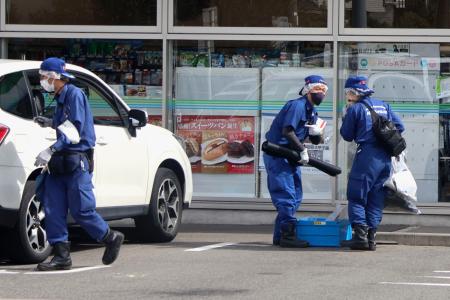 男性が刺される事件があったコンビニを調べる捜査員＝２２日午前、名古屋市中村区