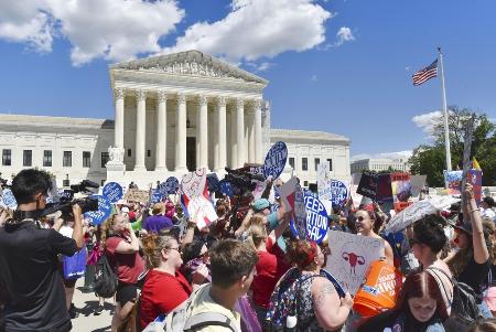 ６月、米連邦最高裁前で互いの主張を訴える中絶擁護派と反対派の市民＝ワシントン