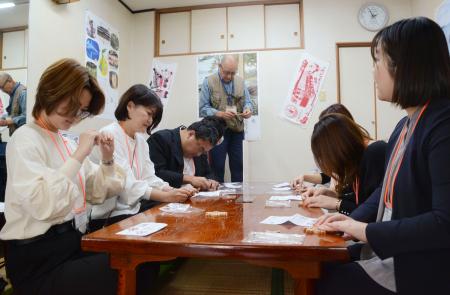 伝統工芸の木工細工の制作を体験する視察ツアーの参加者ら＝２４日午後、石川県七尾市