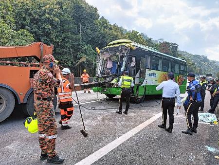 　２４日、マレーシア西部ペラ州の事故現場から移される観光バス（地元消防当局提供・共同）