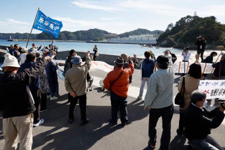 東北電力女川原発（奥）の再稼働に抗議する人たち＝２９日午後、宮城県女川町