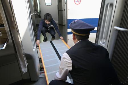 東海道新幹線の三島車両所で行われた訓練で、停電した列車と別の列車を渡り板でつなぐＪＲ東海の社員＝７日午後、静岡県三島市