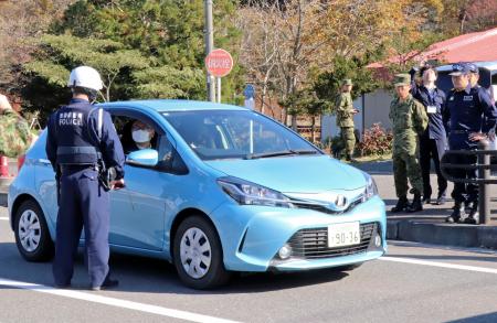 東通原発１号機の重大事故に備えた防災訓練で、国道に合流しようとする車両に乗ったＵＰＺ住民役に自宅で待機するよう促す警察官＝９日午前、青森県東通村