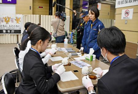 警視庁刑事部の採用イベントで、指紋の採取を体験する学生ら＝９日午後、東京都港区