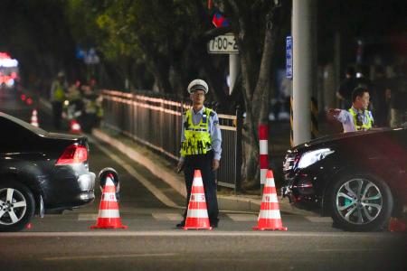 現場となった体育施設の周辺を規制する治安当局者＝１１日、中国広東省珠海市（共同）