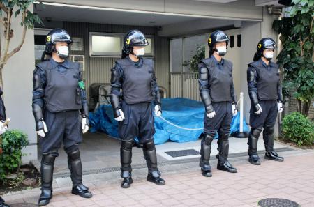 家宅捜索に入った革マル派関係先のマンション前で警戒に当たる警視庁の機動隊員＝１２日午前、東京都新宿区