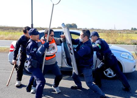 群馬、茨城、栃木の３県警が行った訓練で、犯人役（中央）を取り押さえる警察官＝１２日午前、群馬県板倉町