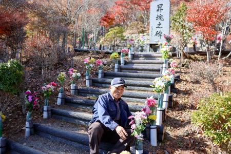 日航機墜落現場「御巣鷹の尾根」の慰霊碑前に造花を供える管理人の黒沢完一さん＝１４日、群馬県上野村