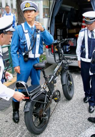 改正道交法が施行され、モペットの車体を調べる警視庁の警察官＝１日、東京都新宿区