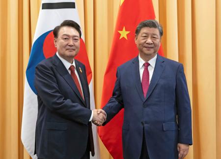 首脳会談を前に握手する中国の習近平国家主席（右）と韓国の尹錫悦大統領＝１５日、ペルー・リマ（聯合＝共同）