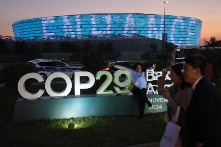 ＣＯＰ２９の会場前で写真撮影をする人たち＝１５日、バクー（ゲッティ＝共同）