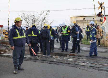 貨物列車の脱線事故で、線路を調べる調査官ら＝１６日午後３時９分、北海道森町